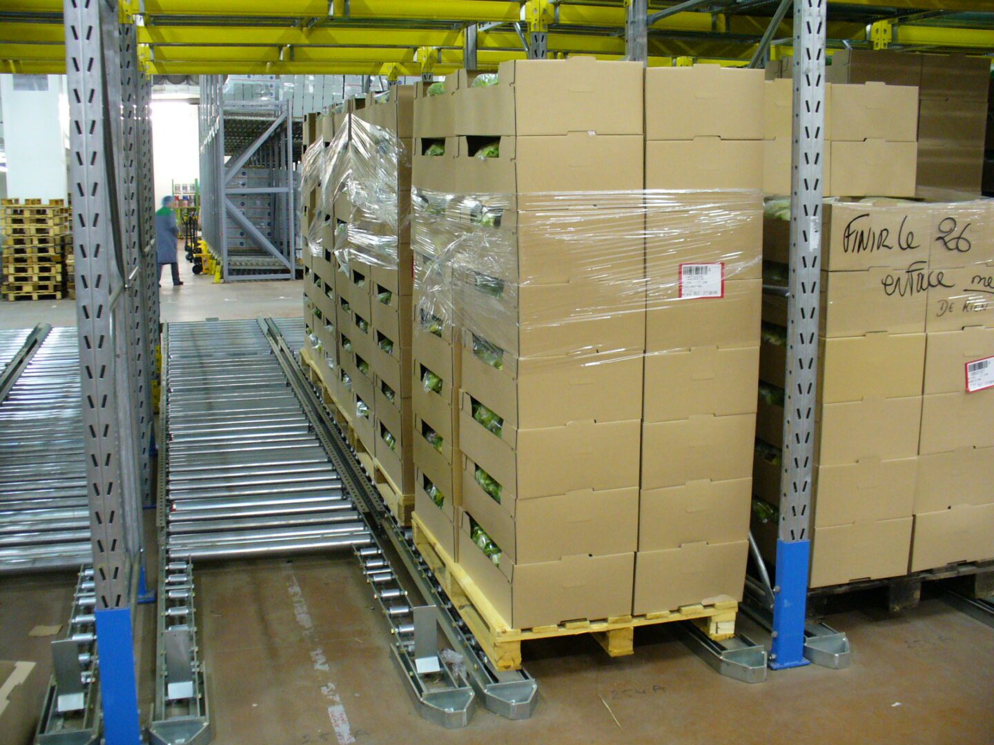 Ligne de stockage dynamique pour picking avec des palettes de cartons dans un environnement de stockage au froid.